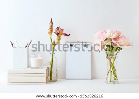 Home interior with decor elements. Mockup clipboard, pink peonies in a vase, interior decoration