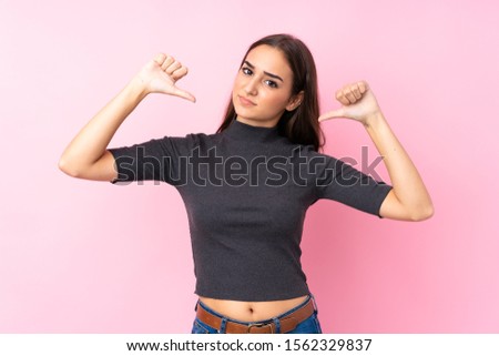 Young girl over isolated pink background showing thumb down