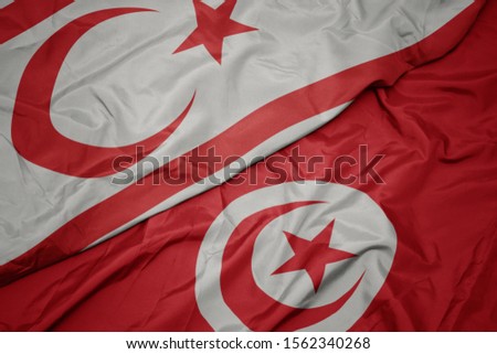 waving colorful flag of tunisia and national flag of northern cyprus. macro