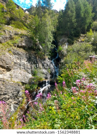 Small water stream coming from Lillaz Waterfalls in Cogne in Aosta Valley, Italy Royalty-Free Stock Photo #1562348881