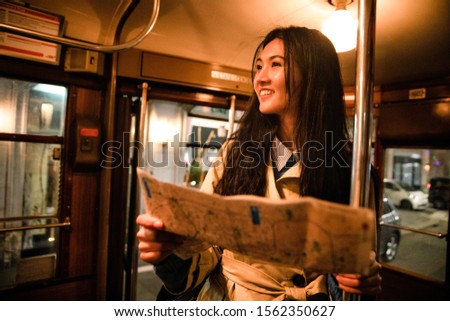 Asian girl use phone in Milan tram