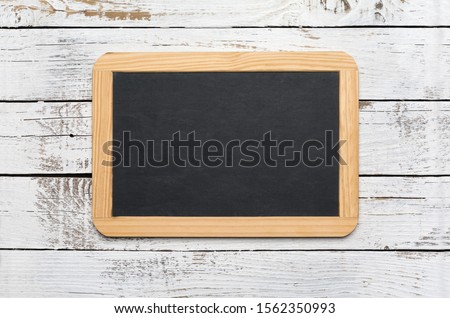 Small vintage blank chalkboard on an old wooden background