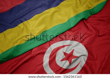 waving colorful flag of tunisia and national flag of mauritius. macro