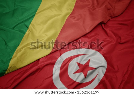 waving colorful flag of tunisia and national flag of republic of the congo. macro