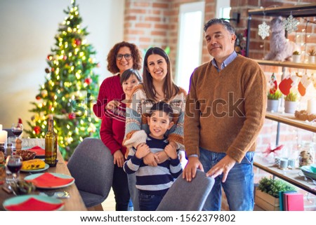 Beautiful family smiling happy and confident. Standing and posing around christmas treeat home