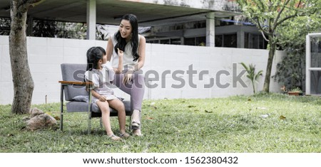 Asian mum and daughter do fun activities in the garden. Mother and her daughter child girl playing together. Happy loving family concept.