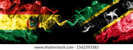 Bolivia, Bolivian vs Saint Kitts and Nevis smoky mystic states flags placed side by side. Concept and idea thick colored silky abstract smoke flags