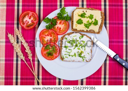 vesper bread on plate with cheese and tomatoes decorated with chives