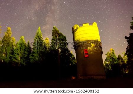 Starry sky background picture of stars in the night sky and the Milky Way. Starry sky over the forest and the water tower.