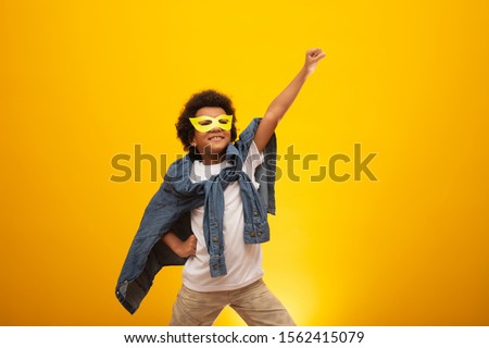Portrait of a young, mixed race boy dressed as a superhero. Black baby in super hero costume. The winner and success concept. Royalty-Free Stock Photo #1562415079