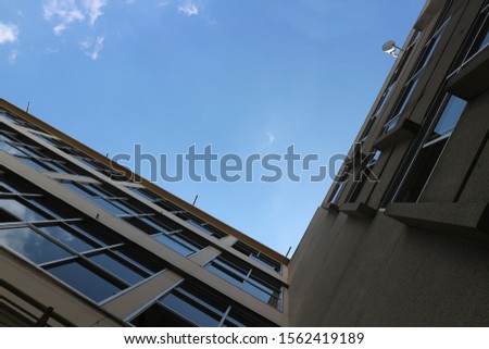 Uprisen angle of high buildings with glasses windows and blue sky, selective focus.