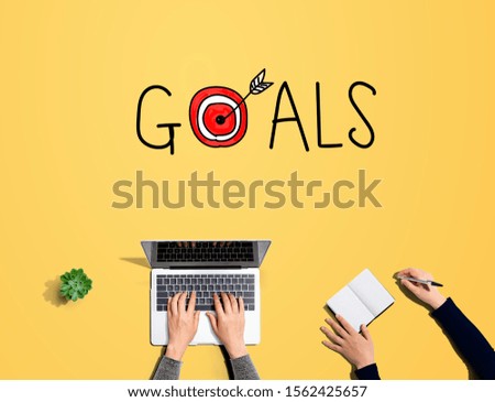 Goal concept with people working together with laptop and notebook