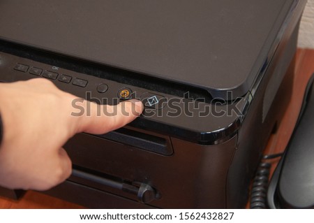 Finger is pushing button to print a page.