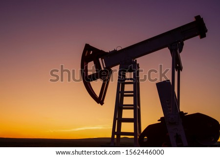 silhouette of an oil pump against the sunset sky, the concept of an economic or global oil crisis, sanctions against Russia