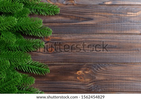 Top view of frame made of fir tree branches on wooden background. Christmas concept with empty space for your design.