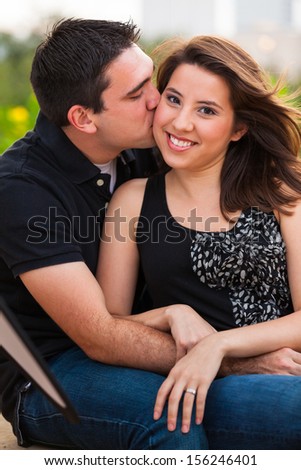 Young couple in a affectionate pose in a urban downtown park  setting.