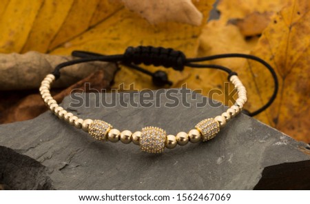 Gold unisex bracelet on background