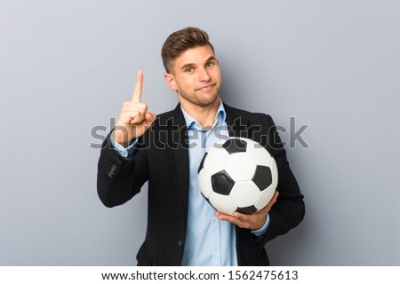 Young soccer trainer showing number one with finger.