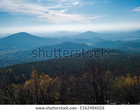 Luzicke hory panorama, view from Hochwald Hvozd, the most attractive view-points of the Lusatian Mountains with autumn colored deciduous and coniferous tree forest and green hills, golden hour light