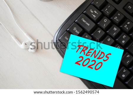 Text sign showing trends 2020. Conceptual photo used to remind someone about an important fact or detail. Text on blue paper with office accessories. Business motivation, inspiration concepts idea.