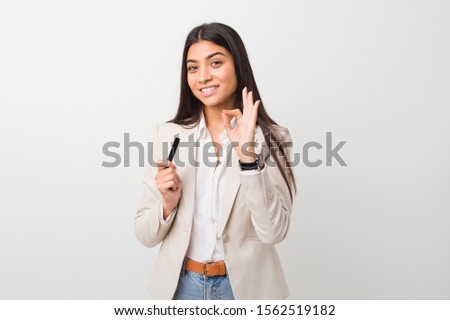 Young arab woman holding a credit card cheerful and confident showing ok gesture.