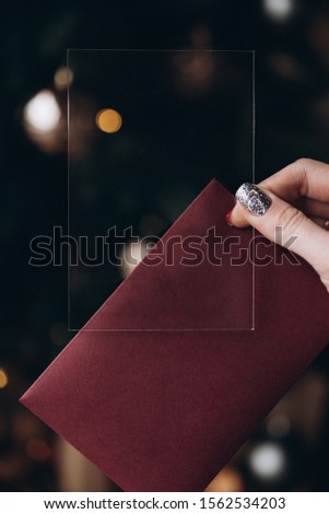 female hand with manicure holds a plastic card for text, background with bokeh. selective focus, film and grain photo