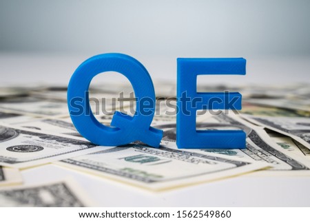 Quantitative Easing Letters On US Dollar Bills Royalty-Free Stock Photo #1562549860