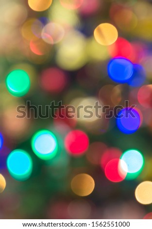 Beautiful festive blurred background with bokeh. Christmas tree colorful garland. Multi-colored lights. Christmas holiday. New Year.