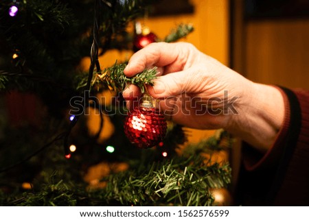 Grandmother hands decorating a Christmas tree