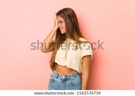 Young slim woman forgetting something, slapping forehead with palm and closing eyes.