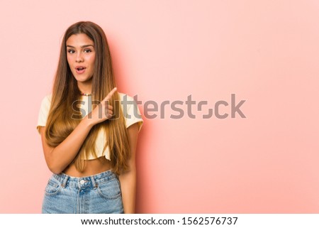 Young slim woman pointing to the side