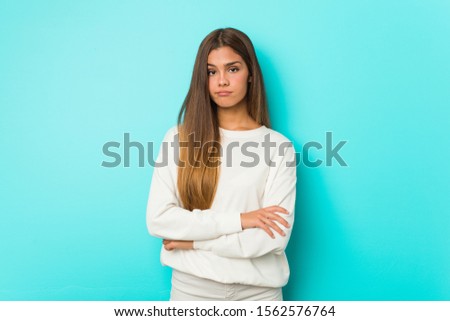 Young slim woman unhappy looking in camera with sarcastic expression.