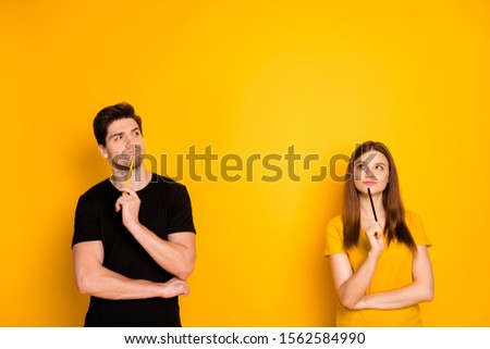 Photo of thoughtful guessing thinking couple of two people pondering over their new project being worked on by them as freelancers isolated over vivid color background in black t-shirt