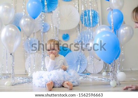 Girl playing with balloons and scenery in blue.