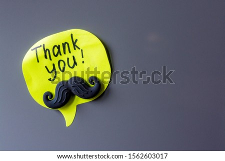 thank you note with a magnetic button in the shape of a mustache on the refrigerator
