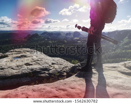 Photographer come to location to taking pictures with camera. Nature landscape photographer with photo equipment on rock.