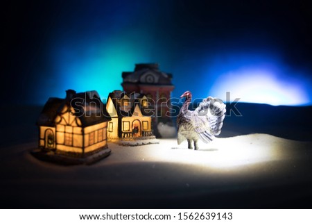Thanksgiving celebration funny concept. Artwork decoration with Turkey tom statue on snow. Selective focus. Empty space for your text