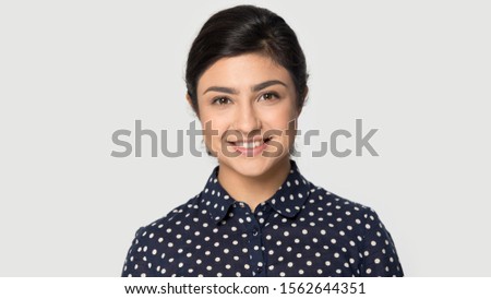 Head shot portrait beautiful smiling Indian girl looking at camera, pretty young woman with healthy beaming toothy smile standing isolated on grey background, satisfied client customer Royalty-Free Stock Photo #1562644351