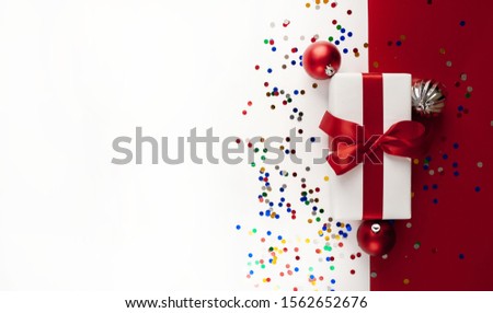 Christmas card, Christmas present with toys on a white and red background, top view with place for congratulations