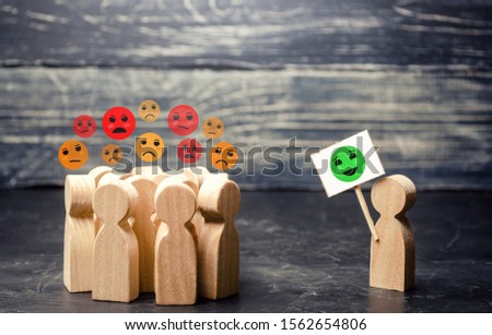 A man with a poster affects an annoyed crowd. Decrease in protest moods, reason and call for humility. Change the bad attitude. Phobias and stereotypes in society. Debunking fake news. Lead Royalty-Free Stock Photo #1562654806