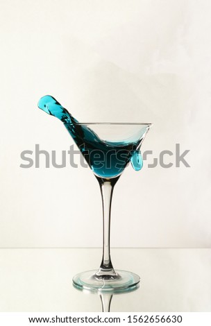 A splash of blue alcohol in a Martini glass.