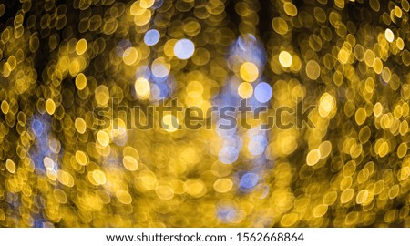 Yellow with blue bokeh lights as background texture. Blurry abstract image like a backdrop.