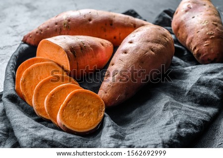 Raw sweet potatoes, organic yam. The farm food. Black background. Royalty-Free Stock Photo #1562692999