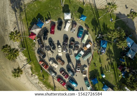 Aerial Drone image of a classic car show in San Diego with Palm Trees and a top down angle on all of the classics