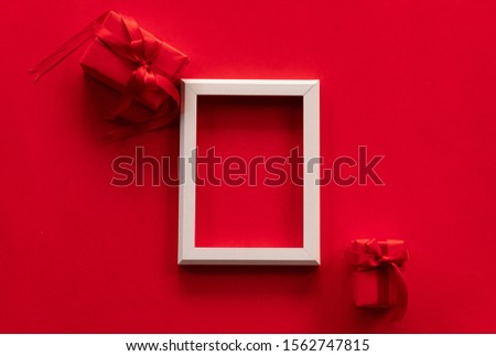 Christmas and New Year concept. Top view. Red gift box , white photo frame on red background with space for your text.
