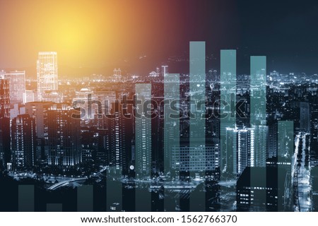Business trading graph on city night background. Royalty-Free Stock Photo #1562766370