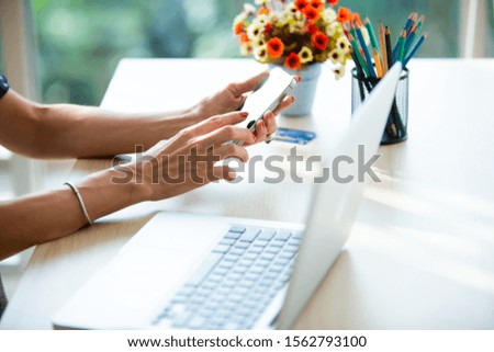 online shopping concepts. Woman hand  holding mobile phone and credit card with Payment Detail page display. using smartphone and laptop computer for online shopping 