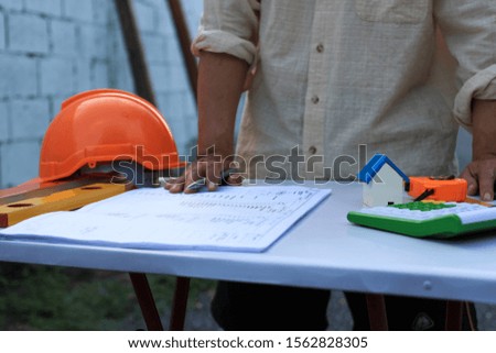 Engineers are writing​ at​ construction designs for​ customers.