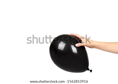Hand with black inflateble balloon, party event decoration, glossy ball. Isolated on white background. Copy space template, mockup.