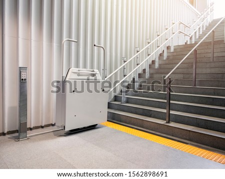 Wheelchair lift with stairs Disability elevator Indoor Public building Universal design facility  Royalty-Free Stock Photo #1562898691